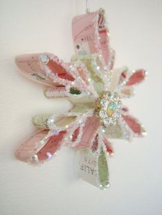 an ornament hanging from the side of a wall decorated with pink and white flowers