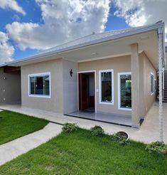 a house that is in the middle of some grass and has two doors on each side