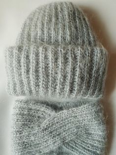 a gray knitted hat with a bow on it's side and a white background