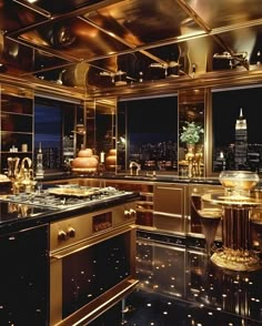 a kitchen with black counter tops and gold accents on the walls, along with large windows