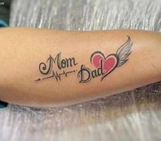 a woman with a tattoo on her arm that says i love mom and dad,