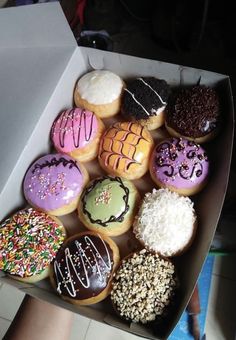 a box filled with lots of different flavored donuts