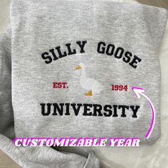 Silly Goose University Embroidered Sweatshirt. A custom year personalization option is available; if left empty year will be randomly generated.  Hello there! Please message me if you have any additional questions or want to change thread colors. We are a family-run Etsy page; my husband and I make all orders from home. You can also send us a message if you would like a custom sweatshirt/t-shirt with whatever words and images, and we will see if we can accommodate your order! HOW TO ORDER - Plea Embroidered University Sweatshirt, Silly Goose University Sweatshirt, Silly Goose Embroidery, Silly Goose University, Personalized Sweatshirts, Cute Crewneck Sweatshirt, Funny Clothing, Cute Crewneck, Sweatshirt Y2k