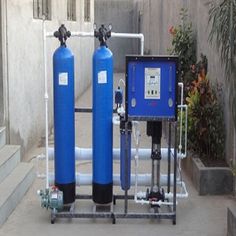 two large blue water tanks sitting next to each other in front of a building with stairs