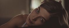 a beautiful young woman laying on top of a bed next to a cat ears head