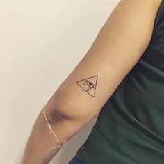 a person with a small triangle tattoo on their arm