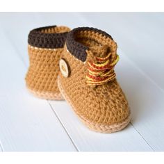 a pair of brown crocheted baby boots with a button on the front and side