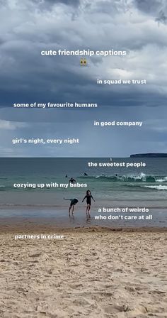 two people are walking on the beach with their surfboards and one is holding a dog