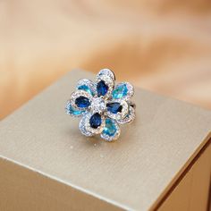 ✰ This delicate lab-created handmade blue flower ring is perfect for people who want to achieve a brilliant and splendid look ✰ This blue handmade ring not only suitable for formal occasions such as banquets, weddings, theme parties, but also for everyday wear ✰ This flower ring vintage is a very special gift for birthday, Mother's Day, Valentine's Day and more  ✰ Comes with an exquisite gift box ✰ Adjustable ring size We also offer the bracelet / necklace/ earring from the same collection: https://www.etsy.com/listing/1214887770/blue-zircon-flower-bracelet-something https://www.etsy.com/listing/1214860766/blue-flower-pendant-with-chain-blue https://www.etsy.com/listing/1218419038/blue-zircon-flower-earring-something Materials: Environmentally-friendly brass Quantity: 1 Piece Ring Size: 0. Blue Flower Rings For Formal Occasions, Blue Promise Flower Ring, Elegant Blue Flower Ring For Formal Occasions, Blue Flower Shaped Jewelry For Anniversary, Elegant Blue Flower Ring As Gift, Flower Shaped Sapphire Jewelry Gift, Blue Flower Ring For Wedding Fine Jewelry, Elegant Adjustable Blue Flower Ring, Gift Blue Gemstone Flower Ring