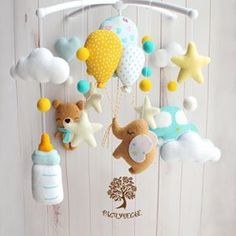 a mobile with stuffed animals hanging from it's sides on a white wooden wall