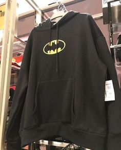 a batman hoodie hanging on a rack in a store