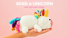 a hand holding a small white crocheted toy with a unicorn on it's back