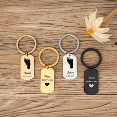 four different key chains with the names and heart shaped tags attached to them on a wooden surface