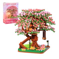 a lego tree with pink flowers on it next to a card board box and instructions