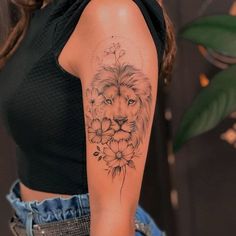 a woman with a lion and flowers tattoo on her arm is looking at the camera