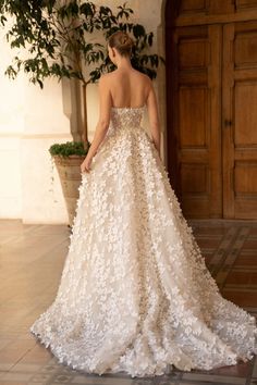 a woman in a wedding dress is standing on the floor with her back to the camera