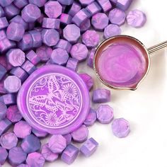 a purple bowl and spoon sitting on top of lavender cubes next to each other