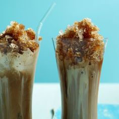 two glasses filled with ice cream and toppings on top of a table next to each other