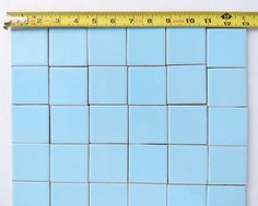 a ruler is on top of a blue tile wall