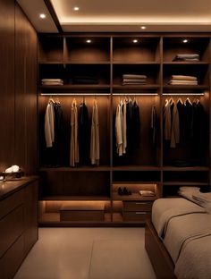 a large walk in closet with clothes hanging on the walls