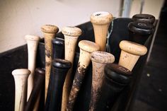 there are many baseball bats in the holder