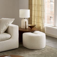 a living room scene with focus on the chair and ottoman that's next to the window