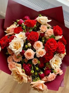 a bouquet of red, white and pink roses