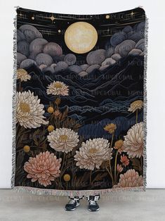 a tapestry hanging on the wall in front of a white wall with black and pink flowers