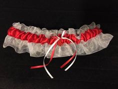 Welcome to GarterShop! Red Sox Inspired Garter Red satin on white organza, adorned with coordinating bows and a Red Sox charm. Garters stretch to 22". Plus size also available, stretching to 30". My bridal garters are handmade using the best quality materials. A wide variety of colors are available. If you don't see the colors you're looking for please contact me. THIS IS NOT A LICENSED PRODUCT.  I AM NOT AFFILIATED WITH THE RED SOX BRAND OR MLB.  THIS PRODUCT IS HANDCRAFTED BY ME WITH LEGALLY PURCHASED LICENSED RED SOX MATERIALS. Prom Garters, Bridal Garters, Wedding Garters, Bridal Garter, Garters, Red Satin, Red Sox, Stretching, Wedding Bridal