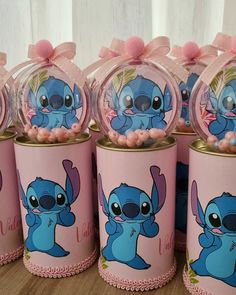 some pink and blue candy tins with cartoon characters on them sitting on a table