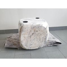 two marbled stools sitting on top of each other in front of a wall