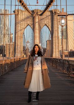 a woman standing on a bridge with her arms in the air