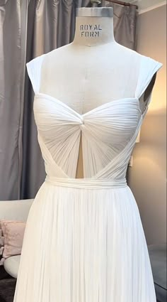 a white dress is displayed on a mannequin