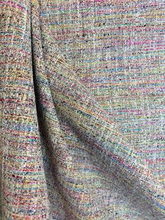 a close up view of the fabric on a jacket with multicolored tweeds