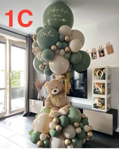 a teddy bear sitting on top of a bunch of balloons