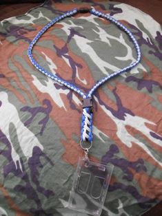 a blue and white lanyard with an id badge attached to it on a camo blanket