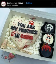 a heart shaped cake in a box decorated with frosting and spooky decorations