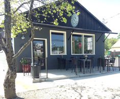 an outside view of a restaurant with tables and chairs in front of the building,