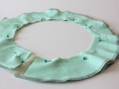 a circle made out of fabric with buttons on the side and thread running through it