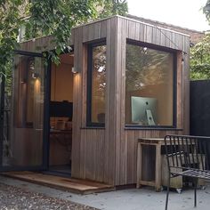 a small wooden building with a laptop on the desk in it's window sill