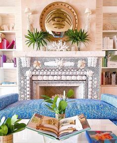 a living room filled with furniture and a fire place in front of a fireplace covered in books