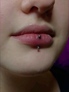 a close up of a person's nose with a piercing in the middle of their lip