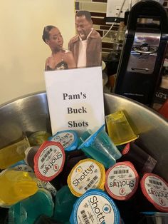 a bucket filled with lots of different types of liquor bottles next to a sign that says pann's buck shots