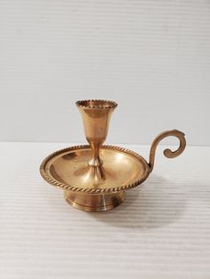 a golden candle holder on a white table