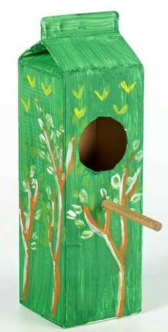 a green box with trees painted on it and a wooden stick sticking out of the top