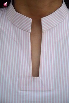 a man wearing a pink and white striped shirt with his neck cut out in half