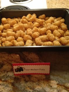 a pan filled with tater tots sitting on top of a counter next to a stove