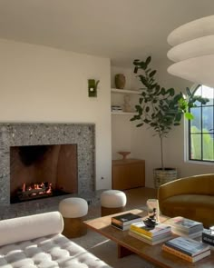 a living room filled with furniture and a fire place in the middle of the room