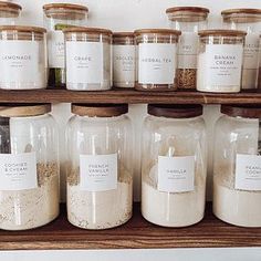 many jars with labels on them are lined up