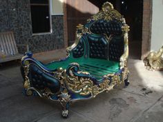 a green and gold bed sitting on top of a cement floor next to a building